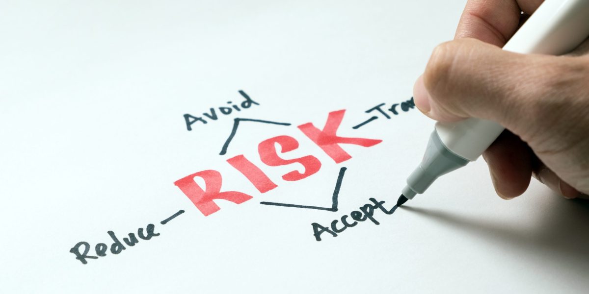 businessman writing risk management concept avoid, accept, reduce or transfer